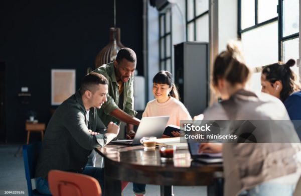 Young professionals or students collaborating in a bright, contemporary co-working environment, displaying teamwork and productivity.